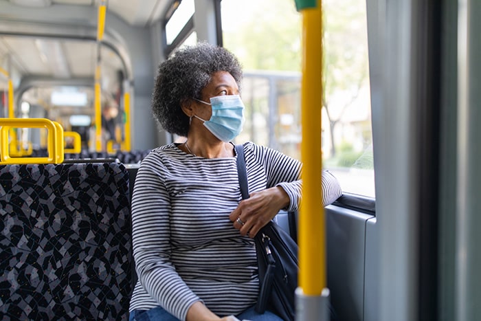 Older woman sitting on a bus, wearing face mask | Covid-19 crisis and unemployment | Ipsos