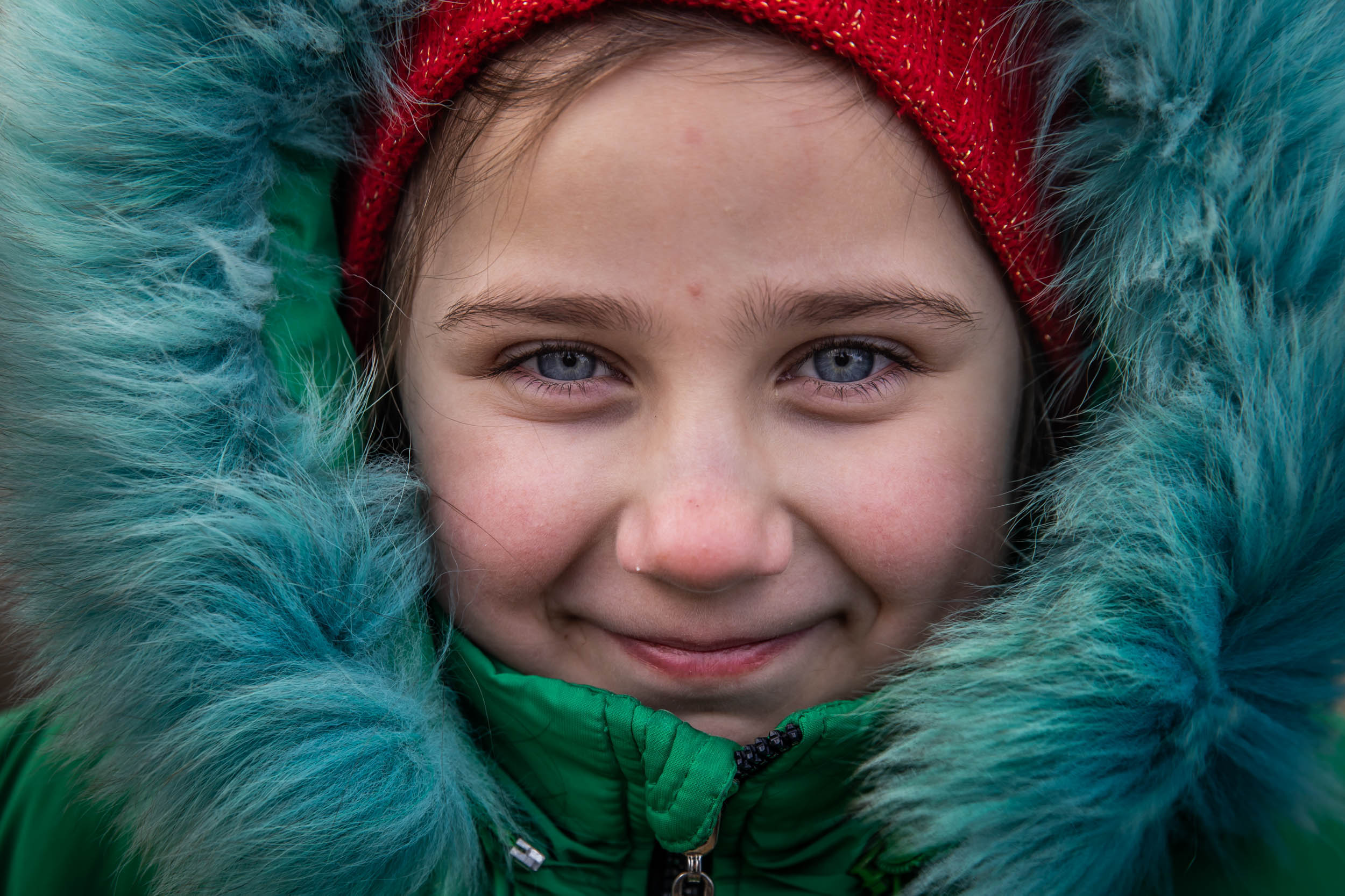 Leeza, age 10, offers a smile while waiting in freezing temperatures to board a bus that would evacuate her and others from the besieged city of Mykolaiv, Ukraine on March 10, 2022.
