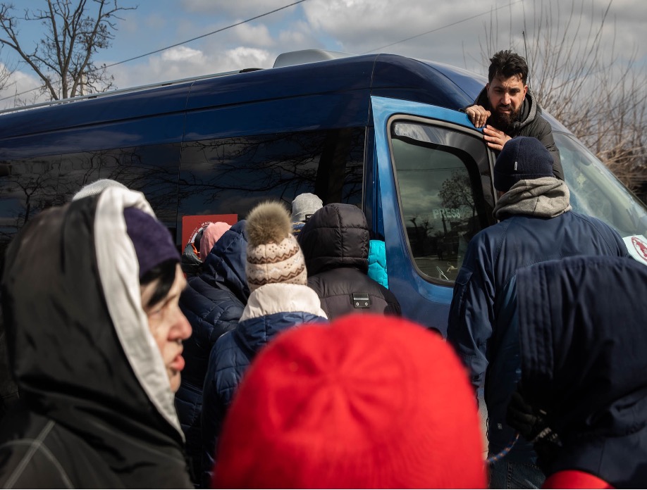 Salam speaks to a crowd of Ukrainians as they prepare to evacuate from Mykolaiv, Ukraine.