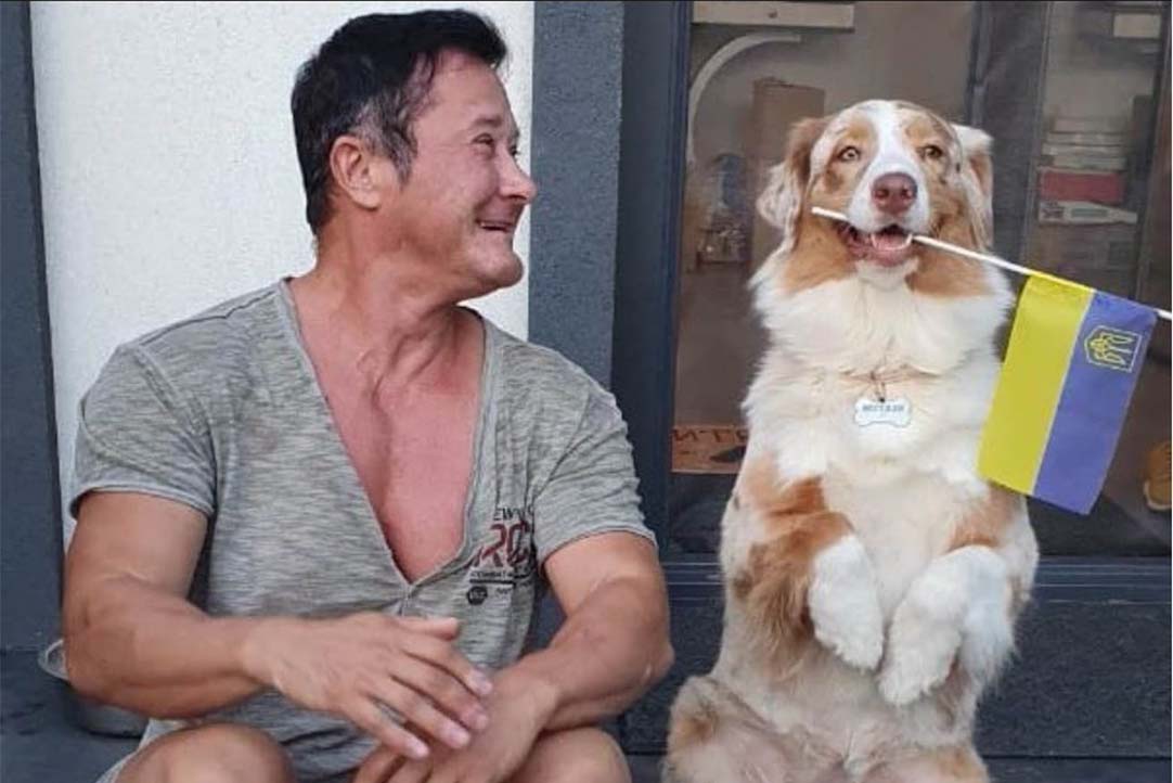 Anna with one of her rescued dogs sitting outside her home in Mykolaiv, Ukraine.