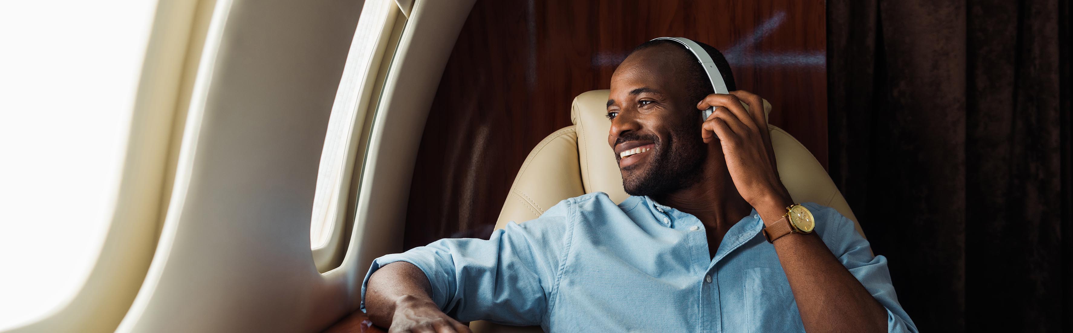 Man wearing headphones on plane | Affluent Survey | Europe | Ipsos