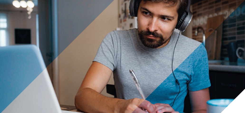 Man with headphones taking notes watching a webinar