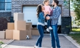 Couple with child in front of house