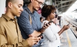 Group of people looking down at their phones