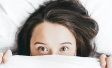 Woman with eyes open in bed