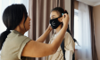Woman putting mask on child