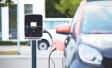 electric car charging station, connected to a black car (blurred)