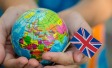 Two hands cup a small globe. They are also holding a union flag.