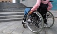 Mensch im Rollstuhl vor einer Treppe