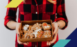 Person holding a box of holiday cookies as a gift
