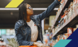 Photo of a woman looking at different items on a shelf at a grocery store