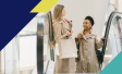 Image of two women riding up a mall escalator