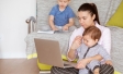 Parent working on laptop surrounded by kids