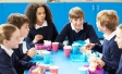 Kids are sitting around a table to have their breakfast