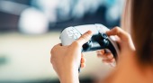 Eine Person die einen weißen Gaming-Controller bedient.