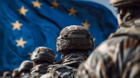 Uniformierte Soldaten stehen mit dem Rücken zur Kamera vor der wehenden EU-Flagge