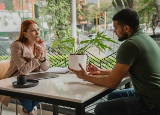 Frau und Mann sitzen sich in einem Cafe gegenüber