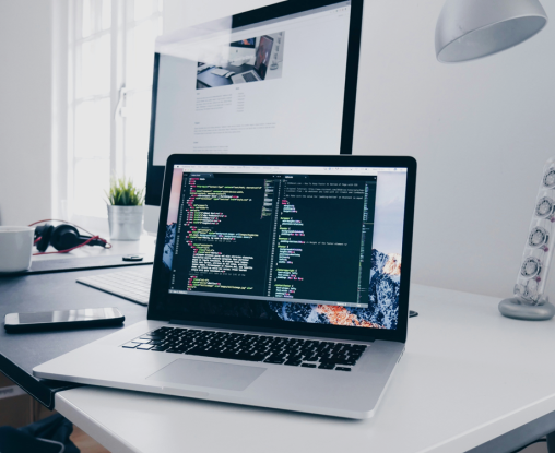 Laptop on desk with code on screen