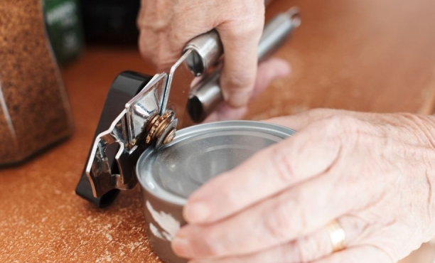 older person using a can opener