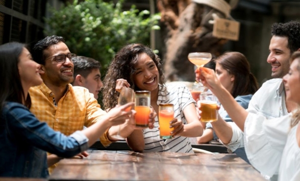 a group of peopel celebrating and toasting with alcoholic and non-alcoholic drinks