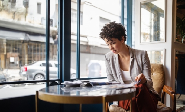 Woman reads the newspaper in a coffee shop