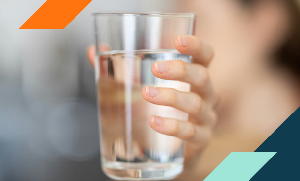 Photo of hand extending a glass of water