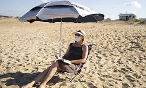 Woman wearing face mask at the beach | consumers' priorities | Ipsos