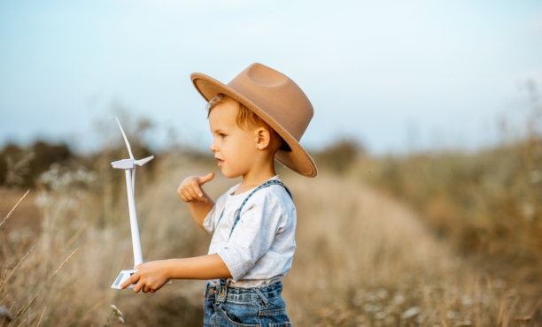 Kind hält Windrad-Attrappe