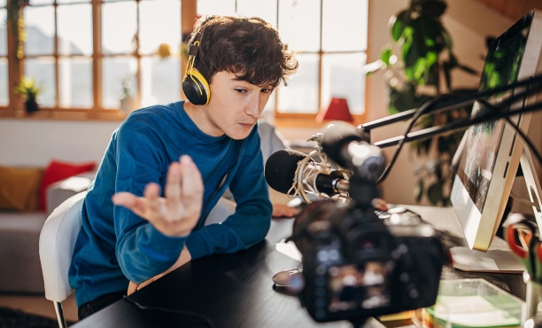  two brothers sitting at home, playing multiplayer online games on computer together. Live streaming on camera.