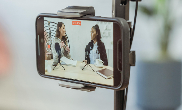 Celular gravando 2 mulheres em um podcast