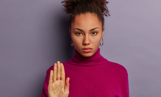 Mulher séria com a mão levantada