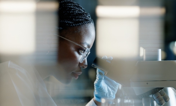 A woman looking through a microscope