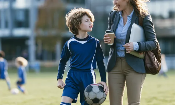 A woman with her son carrying a football