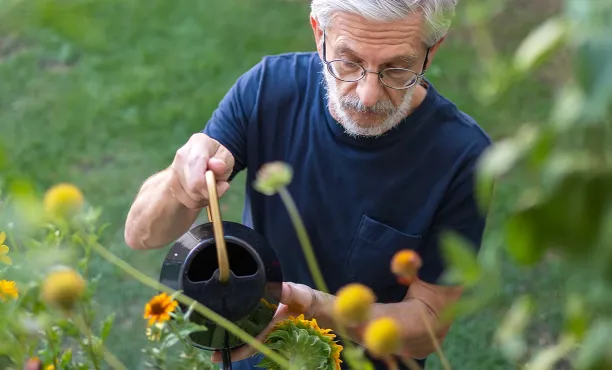A man waters his plants