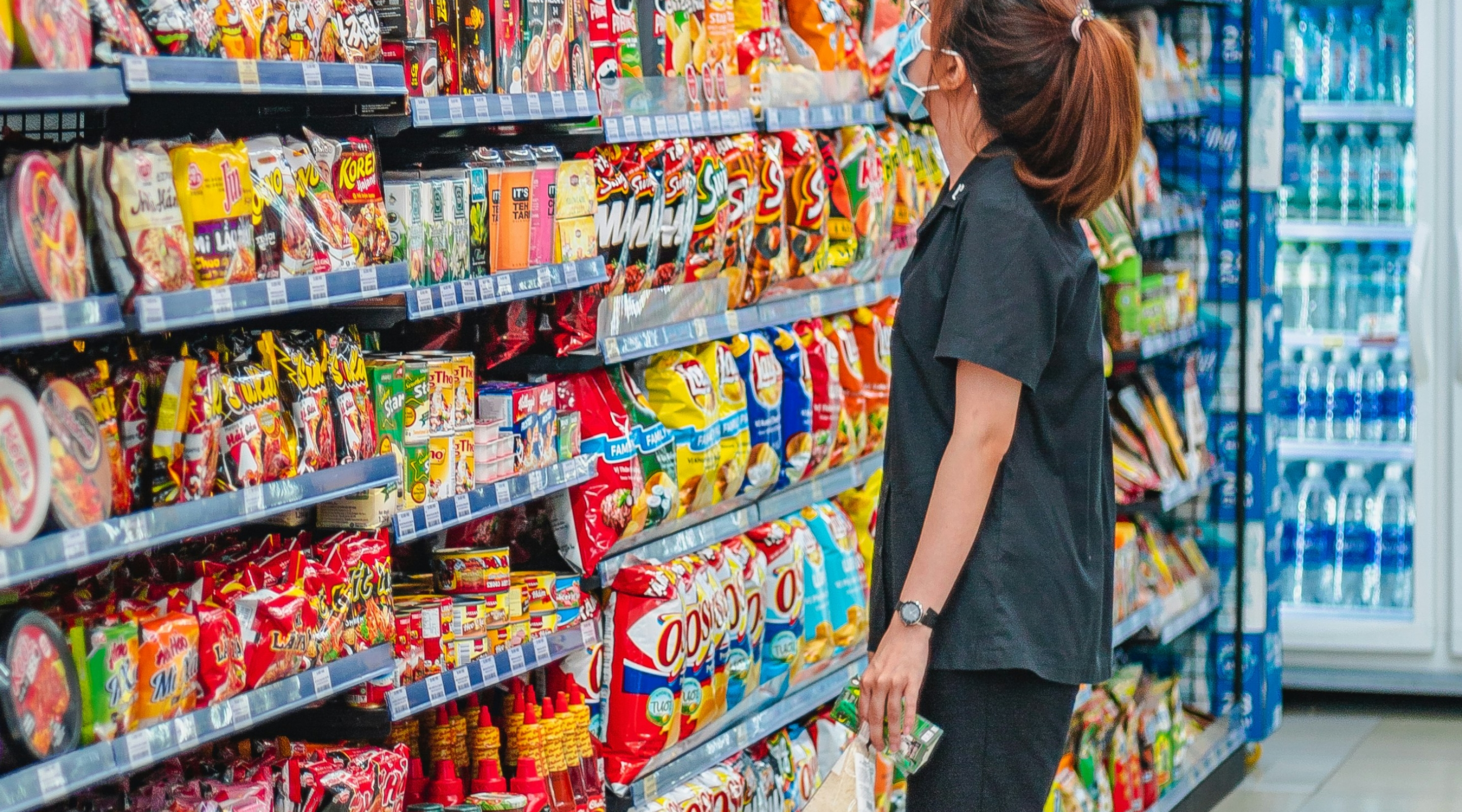 Shopper deciding what to buy at a grocery aisle
