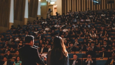 two people presenting to a large room