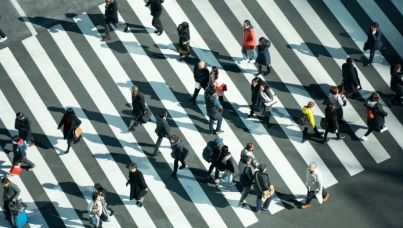 An aerial view of a crowd of people crossing a road