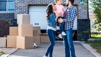 Couple with child in front of house