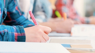 Student Writing on Paper