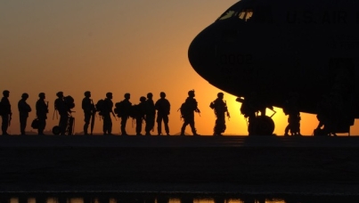 Military personnel boarding an aircraft