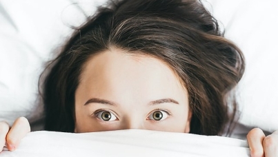 Woman with eyes open in bed