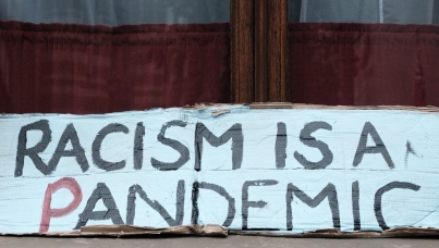 Sign saying "Racism is a Pandemic" 