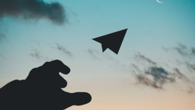 Hand throwing paper plane in air