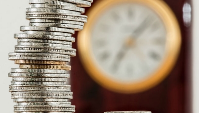 Silver and gold coins with clock in backhground