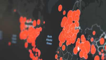 Black map of world showing red spots with COVID 19 outbreaks