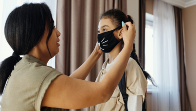 Woman putting mask on child