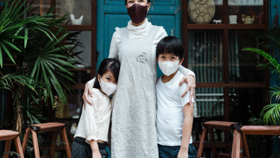 Woman with two children. All wearing masks.