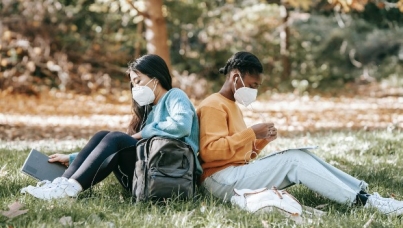 Two Women Sitting Outside Wearing Masks