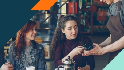 Image of woman paying a waiter at a restaurant with a credit card