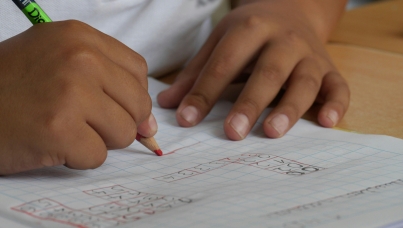 Pupil writing in a classroom